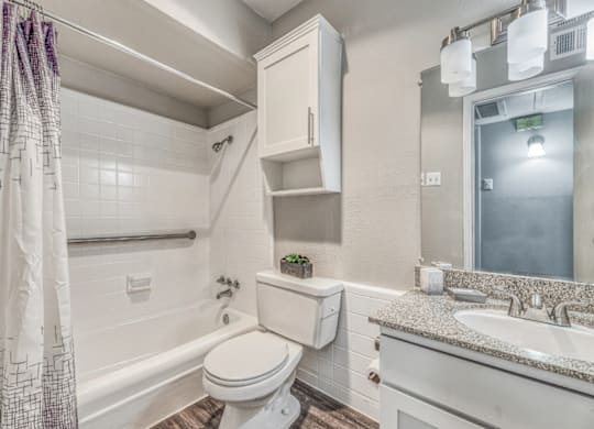 Renovated bathroom with white subway tile at Northwood Heights Apartments, Texas, 75248