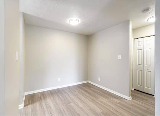 A room with a wooden floor and a white door.