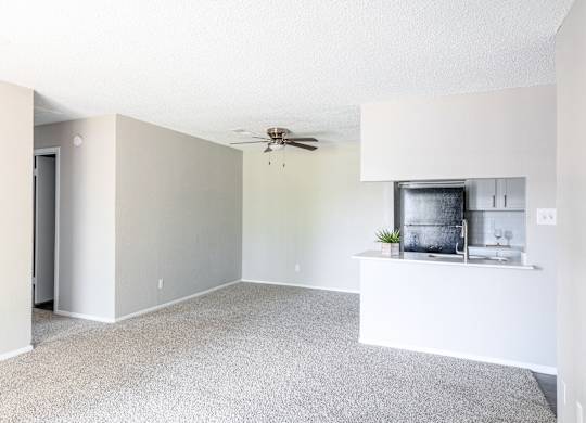 A spacious living room with a ceiling fan and a small kitchenette. at Leander, Texas