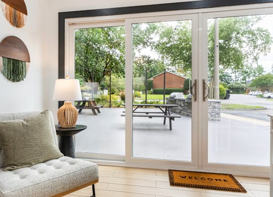A welcoming interior with a view of a park through the glass doors.