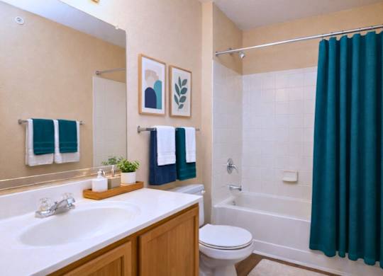 A bathroom with a white sink, a white toilet, a white bathtub, a white shower curtain, a white bathtub, a white towel, a white towel, a white towel, a white