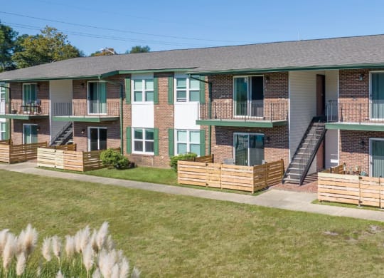 an exterior view of a brick apartment building with a yard and grass