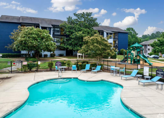 our apartments have a swimming pool with chairs and a playground