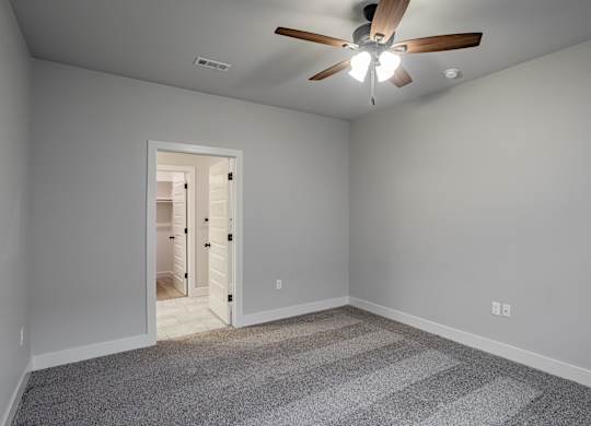 A room with a ceiling fan and a carpeted floor at Cedar Crest Apartments, Farmington, Arkansas