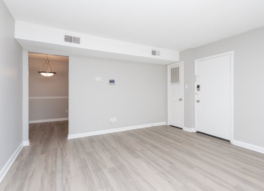 an empty living room with white walls and wood flooring