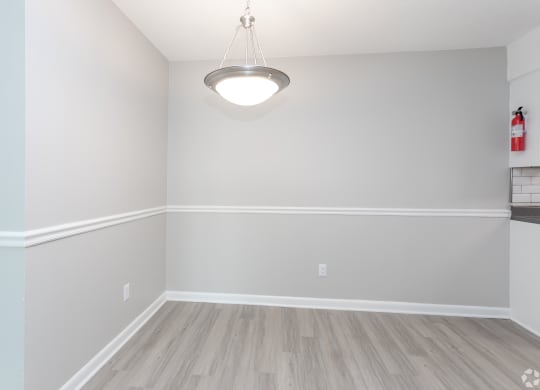 an empty living room with white walls and a light fixture