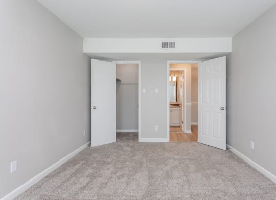 a living room with carpet and a door to a bathroom
