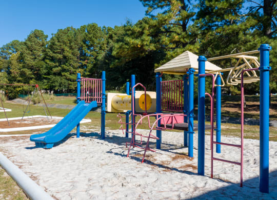 a playground with a swing set and slides at channing apartments