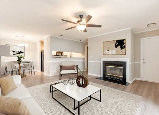 A living room with a fireplace and a white couch. at Rosewood at Colony Square, Rocky Mount