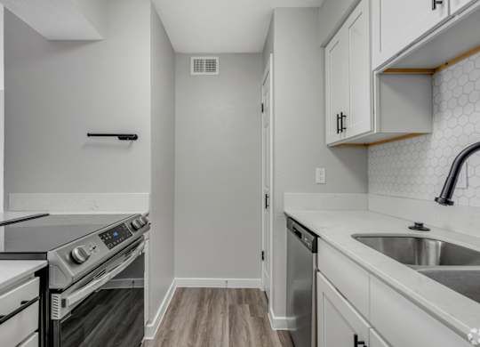 A kitchen with a stove top oven and a dishwasher.