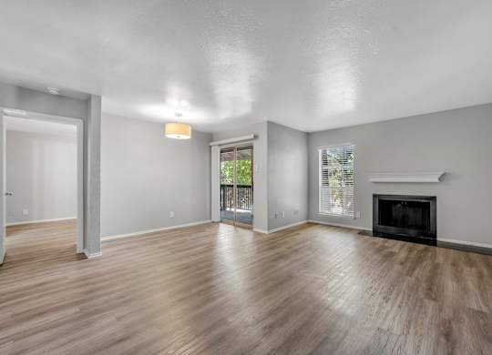 A spacious living room with a fireplace and sliding glass doors.