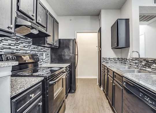 A kitchen with black appliances and a black fridge.