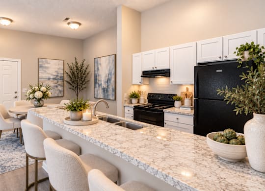 A kitchen with a marble countertop and white cabinets.