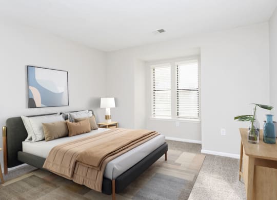 a bedroom with a bed and a desk with a window