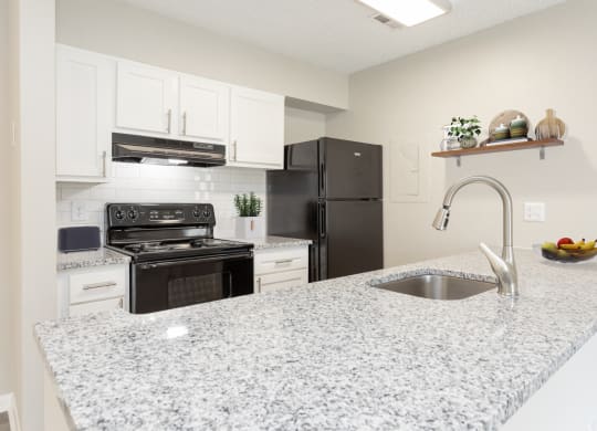 a kitchen with granite counter tops and black appliances