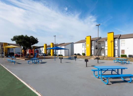 an empty playground with picnic tables and playground equipment at an elementary school at Helios, Dallas, TX