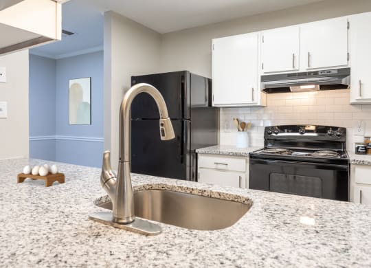 a kitchen with granite counter tops and black appliances