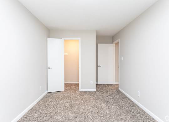 an empty room with white walls and doors