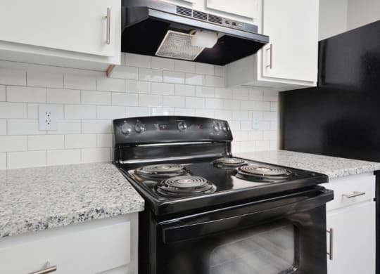 a kitchen with white cabinets and a black stove  at Henley, North Carolina, 28311