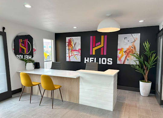 a modern reception area with yellow chairs and a white reception desk