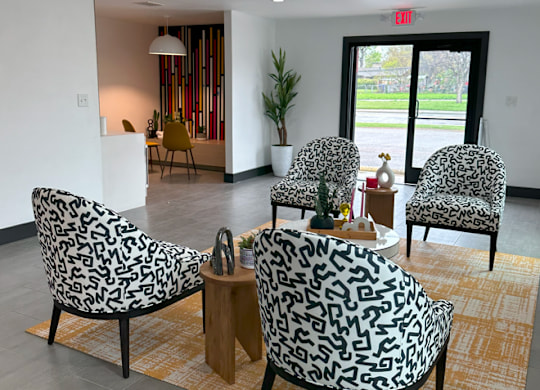 a living room with four chairs and a table