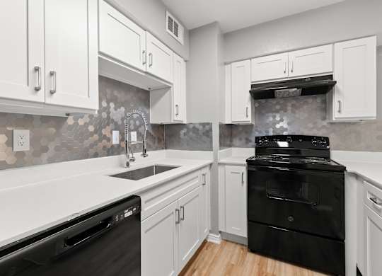 A kitchen with black appliances and white cabinets.at The Sidney, Texas, 75090