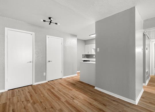 A room with a ceiling fan and a kitchen area.at The Sidney, Sherman, TX 75090