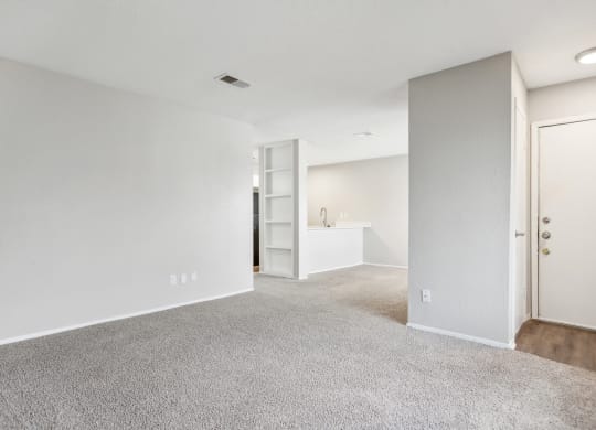 an empty living room with white walls and carpet