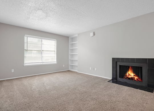 an empty living room with a fireplace and a window
