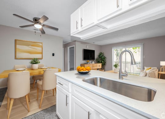 a kitchen and dining room with a sink and a ceiling fan