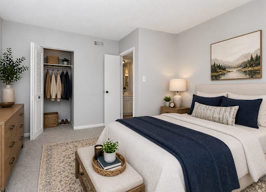 A bedroom with a large bed and a painting on the wall.