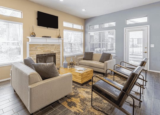 A living room with a fireplace, two couches, and a chair.