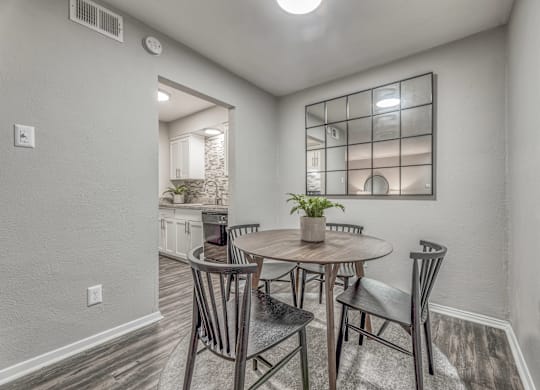 Dining area with round table and gridded mirror at Northwood Heights Apartments, Dallas, 75248