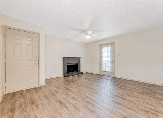 an empty living room with a fireplace and a door