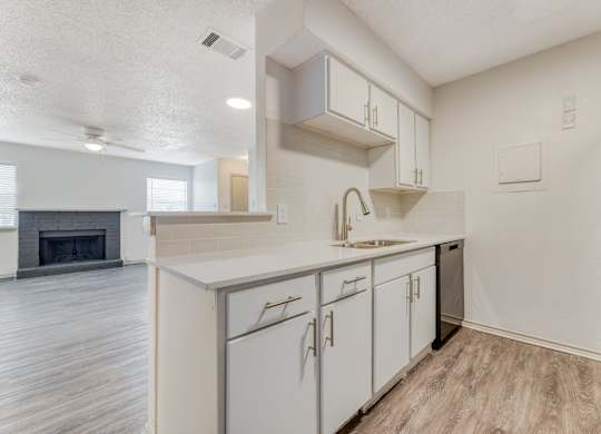 a white kitchen with white cabinets and a stainless steel refrigerator