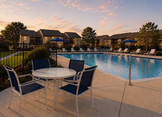 Poolside dining area with seating at dusk at Ridgeview Apartments, Sherman