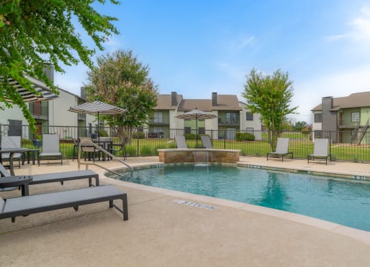 a swimming pool with a house in the background