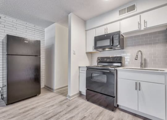 a kitchen with white cabinets and stainless steel appliances and a refrigerator
