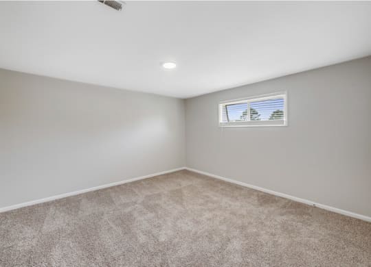an empty room with carpet and a window