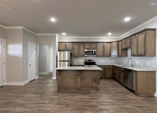 A kitchen with wooden cabinets and a central island at Cedar Crest Apartments, Arkansas