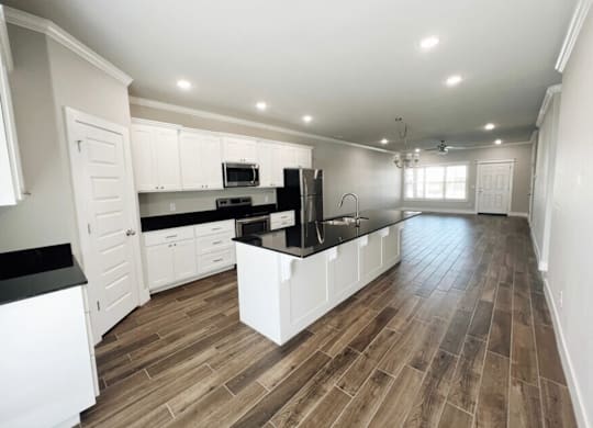 A kitchen with white cabinets and a black countertop at Cedar Crest Apartments, Farmington