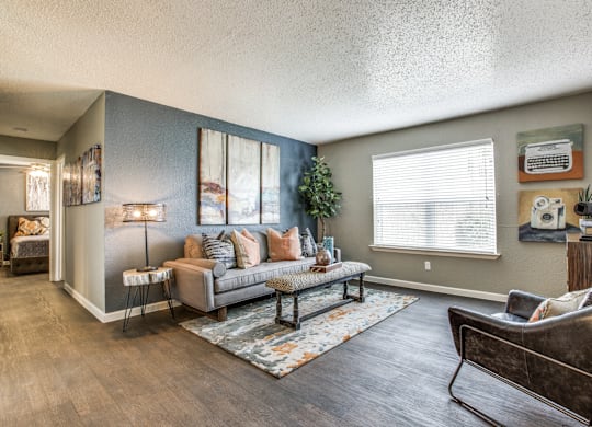 A living room with a grey couch and a brown leather chair.