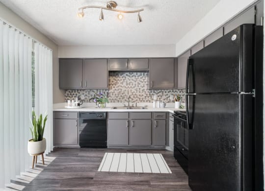 a kitchen with a black refrigerator and a sink  at Shadow Ridge, Texas, 76013