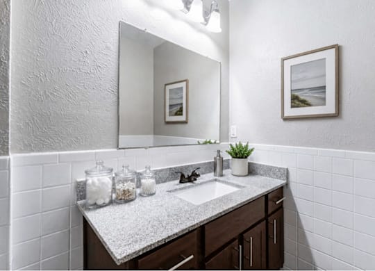 Bathroom vanity with subway tile and framed mirror at Ridgeview Apartments, Texas