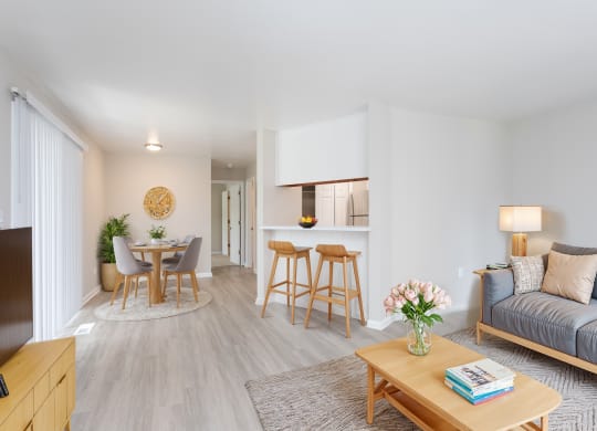 a living room with a couch and a coffee table and a dining room and kitchen