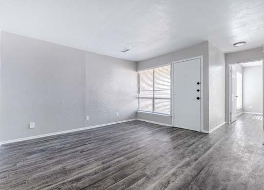 Empty living room with gray luxury vinyl flooring at Ridgeview Apartments, Texas, 75092