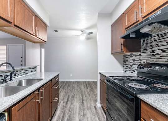 Kitchen with stainless sink and wood cabinetry at Ridgeview Apartments, Sherman