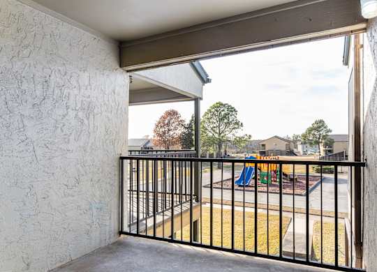 Private balcony overlooking playground and grassy courtyard at Ridgeview Apartments, Texas