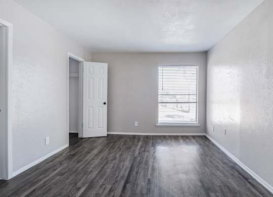 Empty bedroom with gray walls and vinyl flooring at Ridgeview Apartments, Sherman