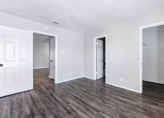 Empty room with multiple doorways and vinyl flooring at Ridgeview Apartments, Texas